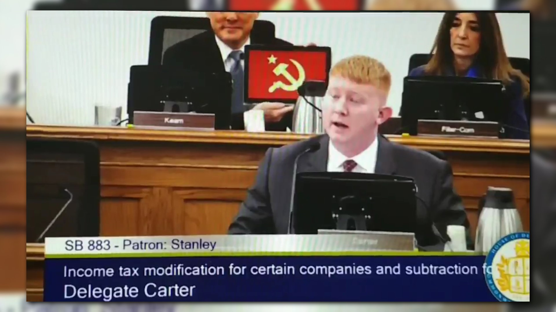 Democratic Lawmaker Holds Hammer And Sickle Behind Colleague